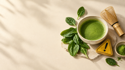Spinach leaves, a bowl of matcha and a yellow warning triangle on a cream background.