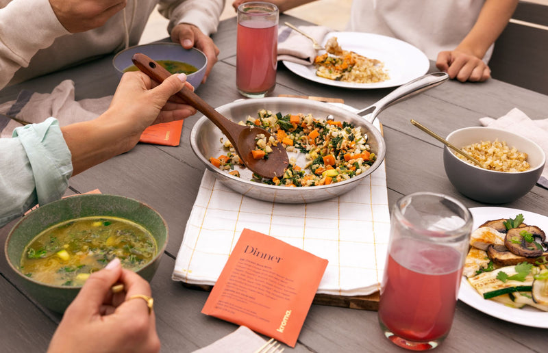People enjoying a meal together at a table with various dishes and drinks.