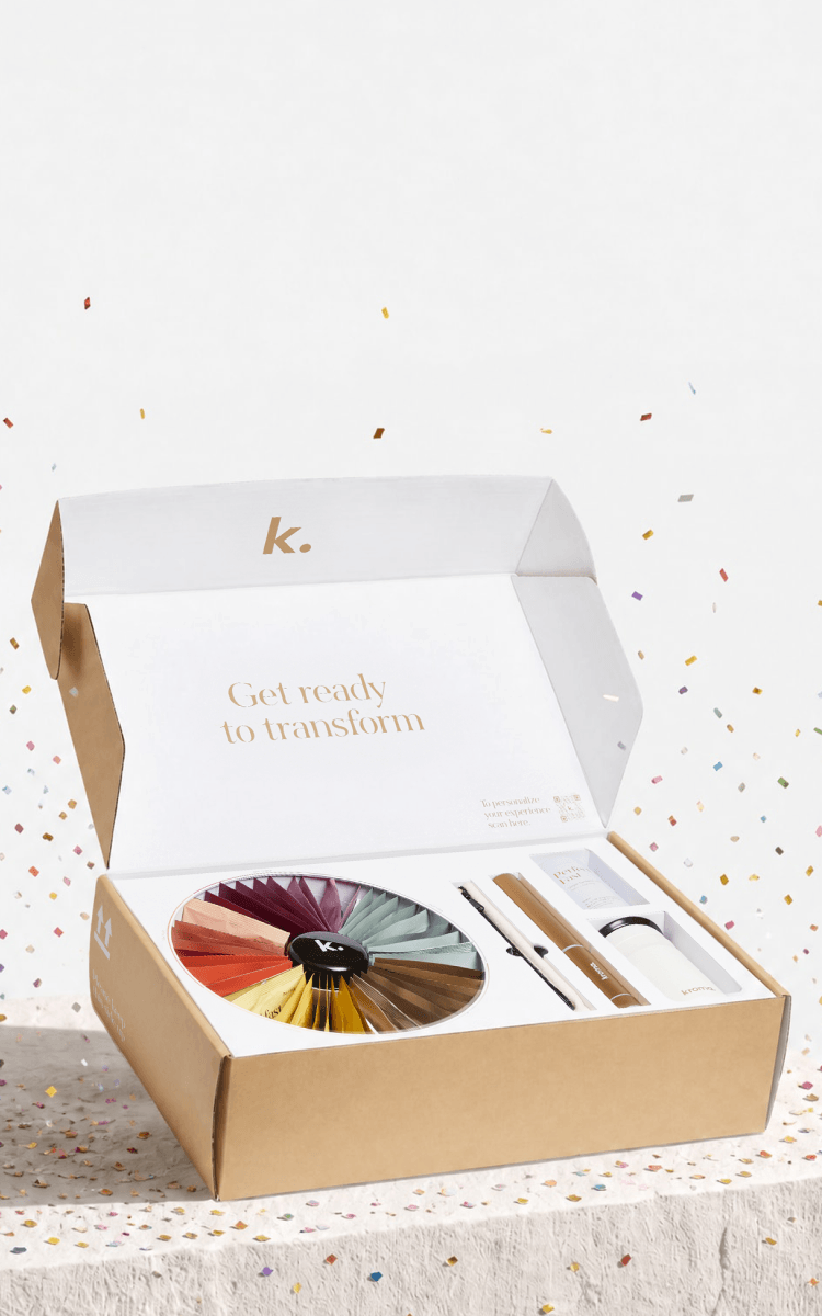 An open Kroma Reset box on a white surface with confetti scattered around it. Inside is a round multicolor color wheel palette and several slim cosmetic-style tools or inserts.