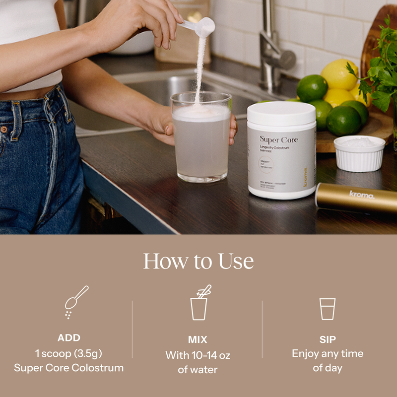 Person pouring a scoop of Super Core Colostrum into a glass on a kitchen counter.